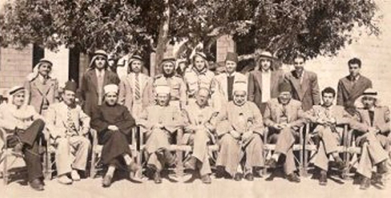 巨大なイナゴマメの木陰に集まるイギリス委任統治時代のパレスチナ人たち