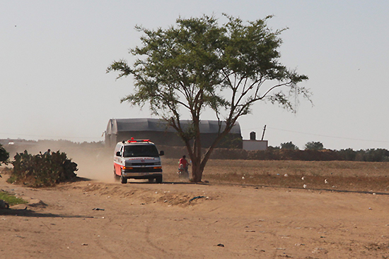 緩衝地帯の農地横を通り過ぎる救急車（写真提供：PARC Gaza）